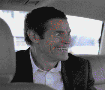 Willem Dafoe smiles creepily and nervously